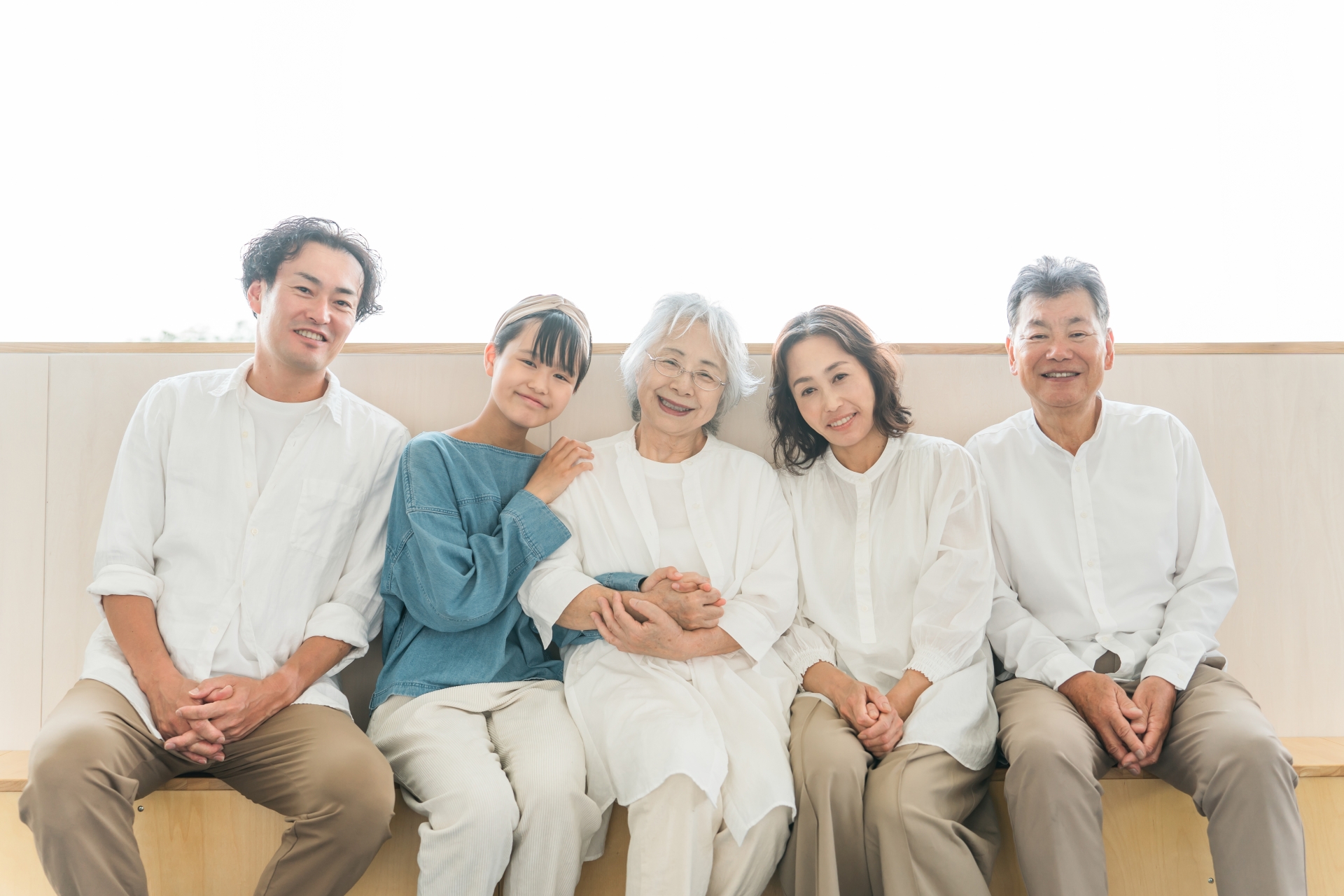 ソファに並んで笑っている三世代の家族