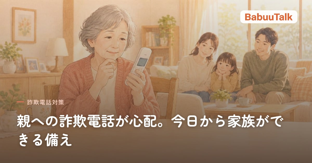 居間で固定電話の子機を持ち、画面を見て少し考えている高齢の女性。奥のソファに家族の姿